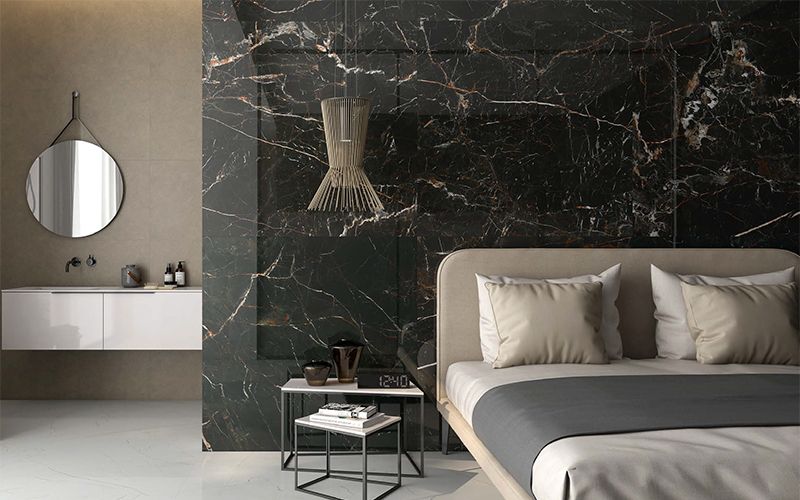 Slaapkamer met accentmuur in XXL keramische tegels in zwart bruine marmerlook saint laurent.