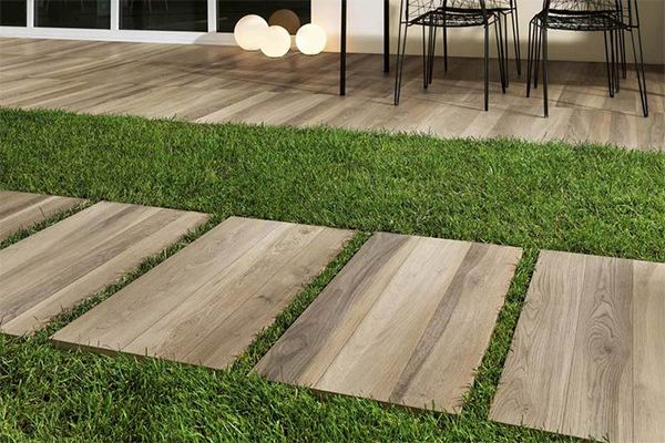 Keramische houtlook terrastegels op het terras of als stapstenen. Deze collectie tegels voor het terras bestaat in verschillende formaten zoals 60x60x2cm en 30x160x2cm