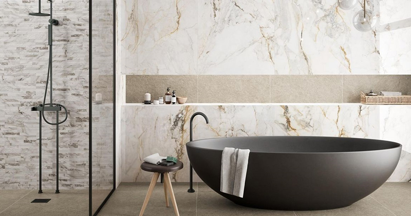 Badkamer met marmerlook wandtegels met gouden accenten.