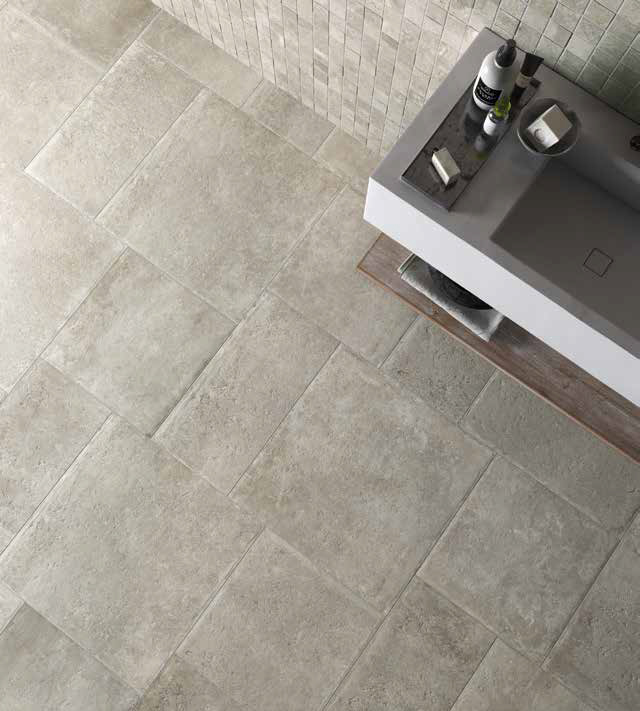 Landelijke badkamer met grijze tegels in legpatroon.