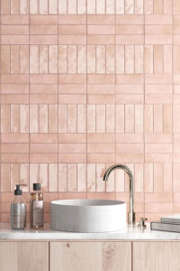 Wand in het toilet met roze wandtegels 5x15cm in keramische zelliges. De tegeltjes werden geplaatst in een speciaal patroon met mix van mat en blinkend