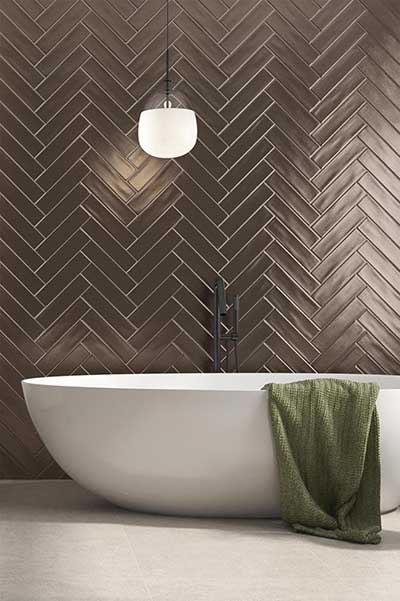 Luxe badkamer met gouden wandtegels in visgraatmotief zorgt voor een elegante hotel chique uitstraling. De glanzende afwerking reflecteert het licht en versterkt het ruimtelijk gevoel.